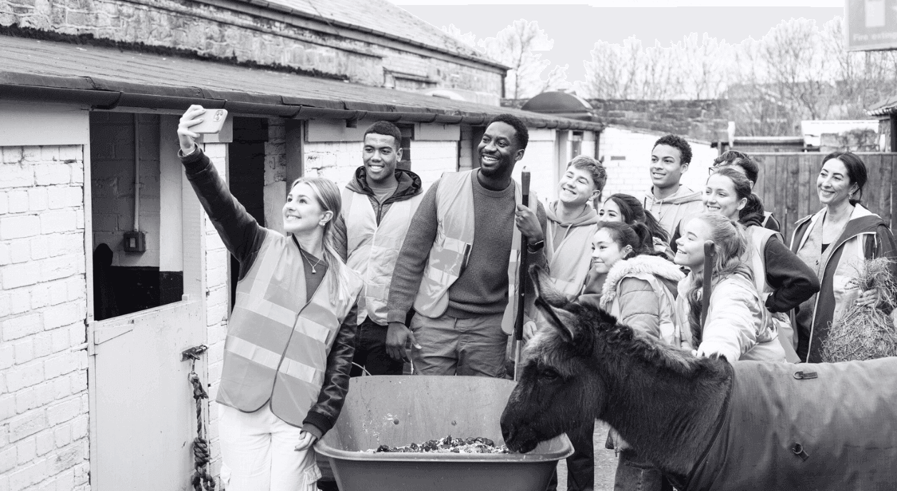 A group of young volunteers taking a selfie at a farm.