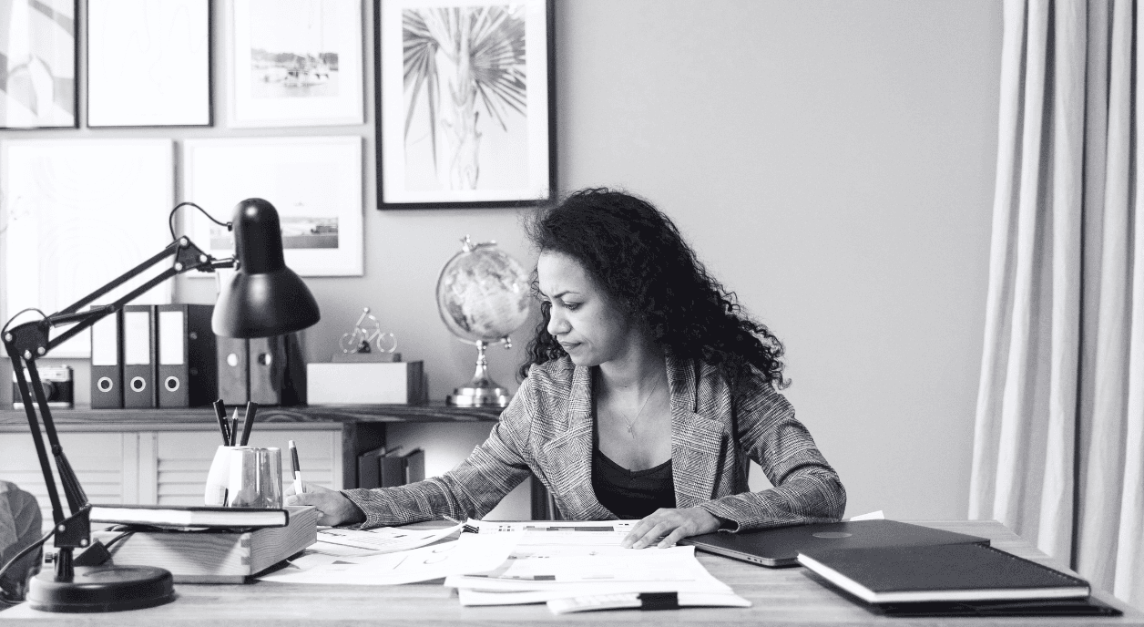 A Black woman at a desk working on nonprofit budget documents.