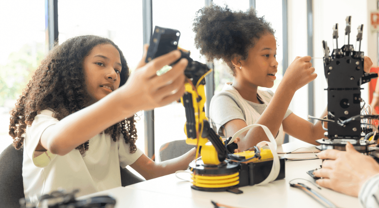 Two young girls learning about robots.
