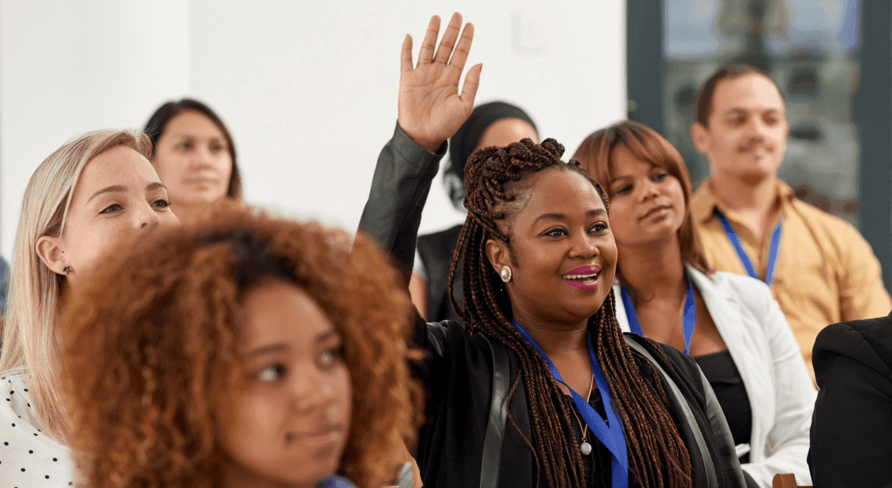 A volunteer raising her hand in a meeting.
