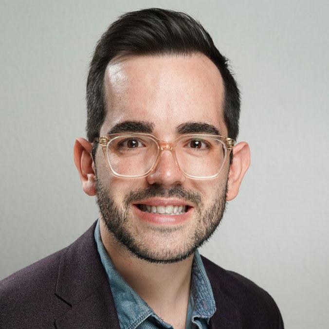 Headshot of Brian Schultz, director of partnerships at Candid, in a blue shirt and gray jacket.