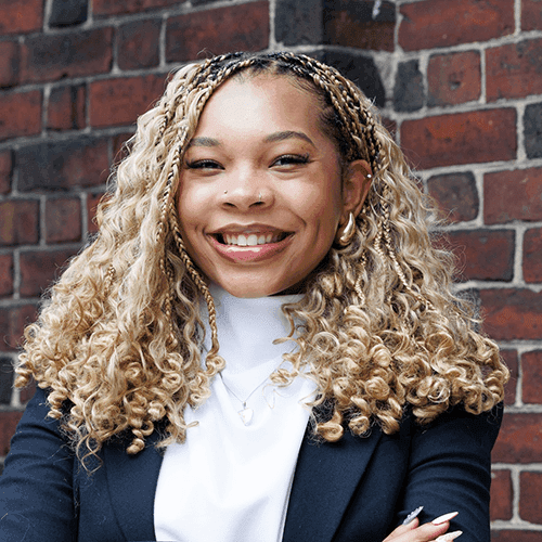Headshot of Allison Swann, CBA intern, fall 2024, in a white top and blue jacket.