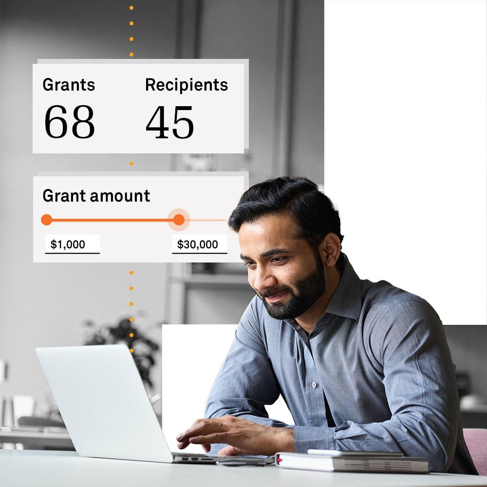 Man at computer researching grant data.