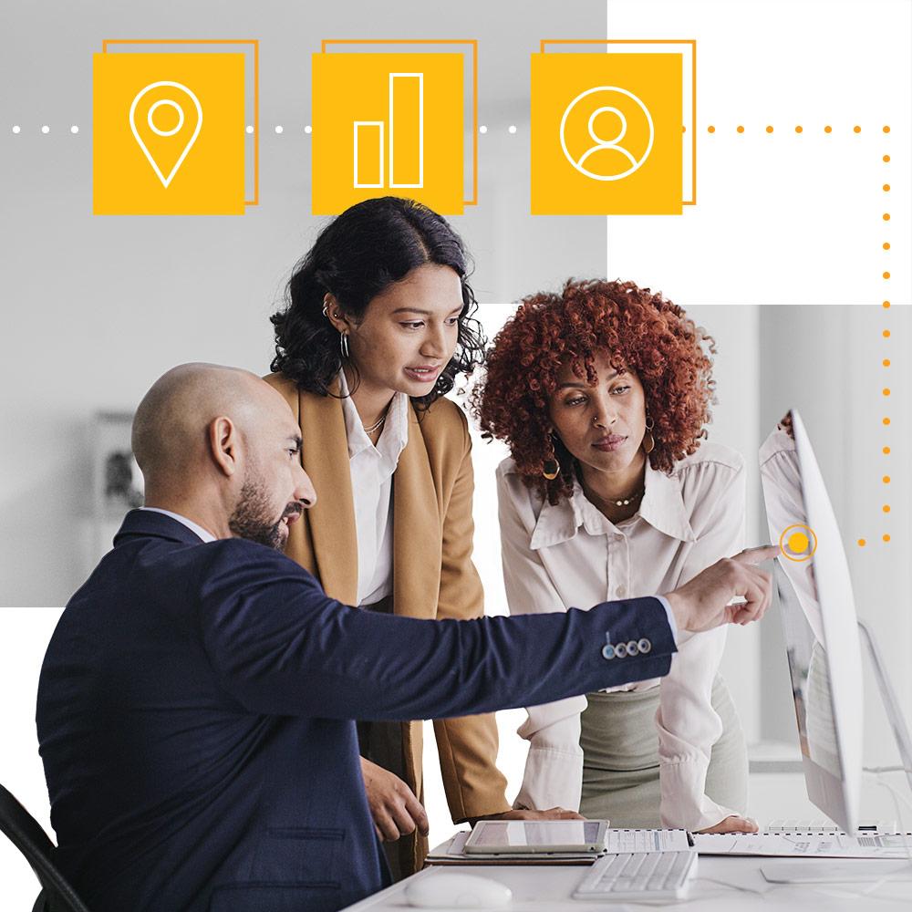 Three colleagues looking at datasets on a monitor.