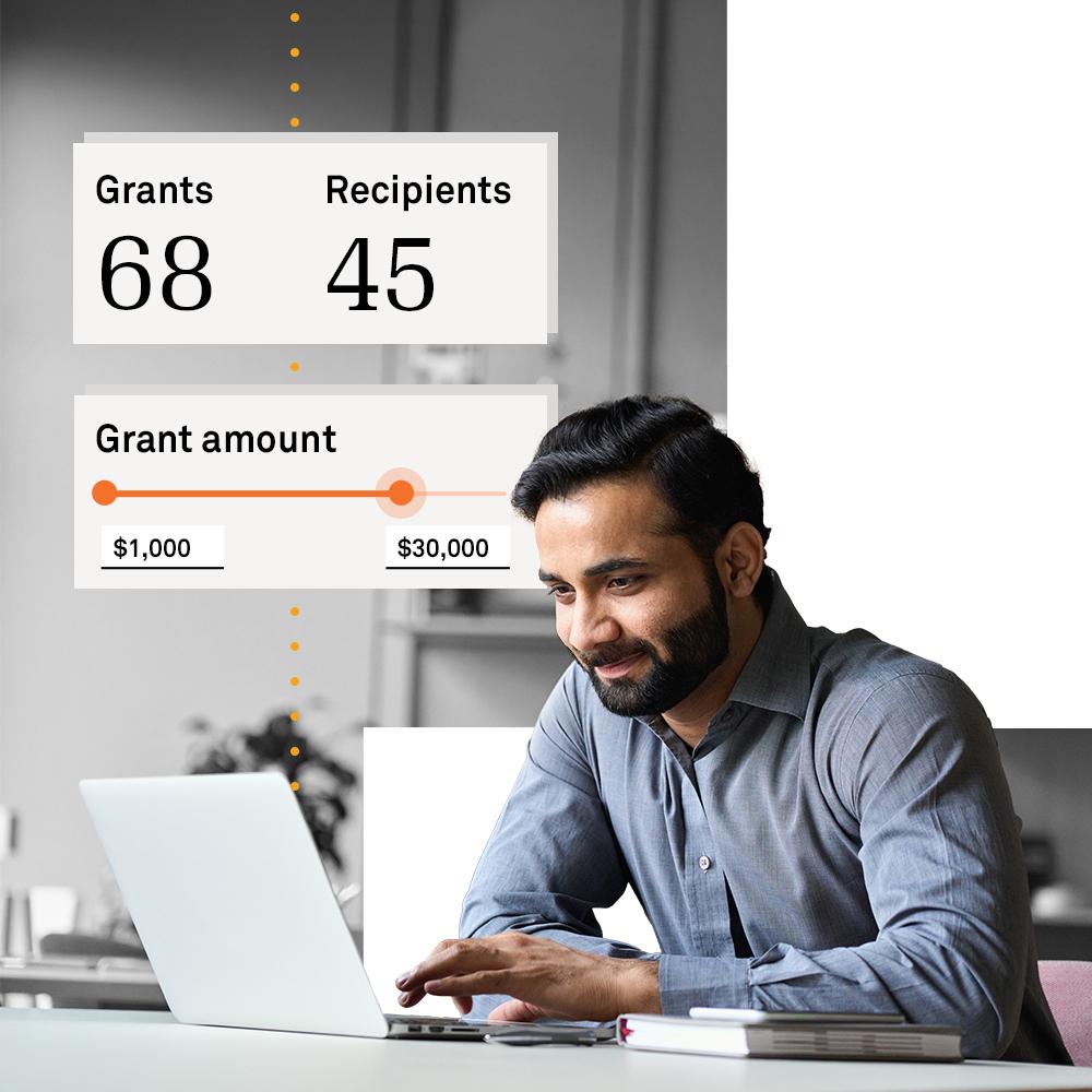 Man at computer researching grant data.