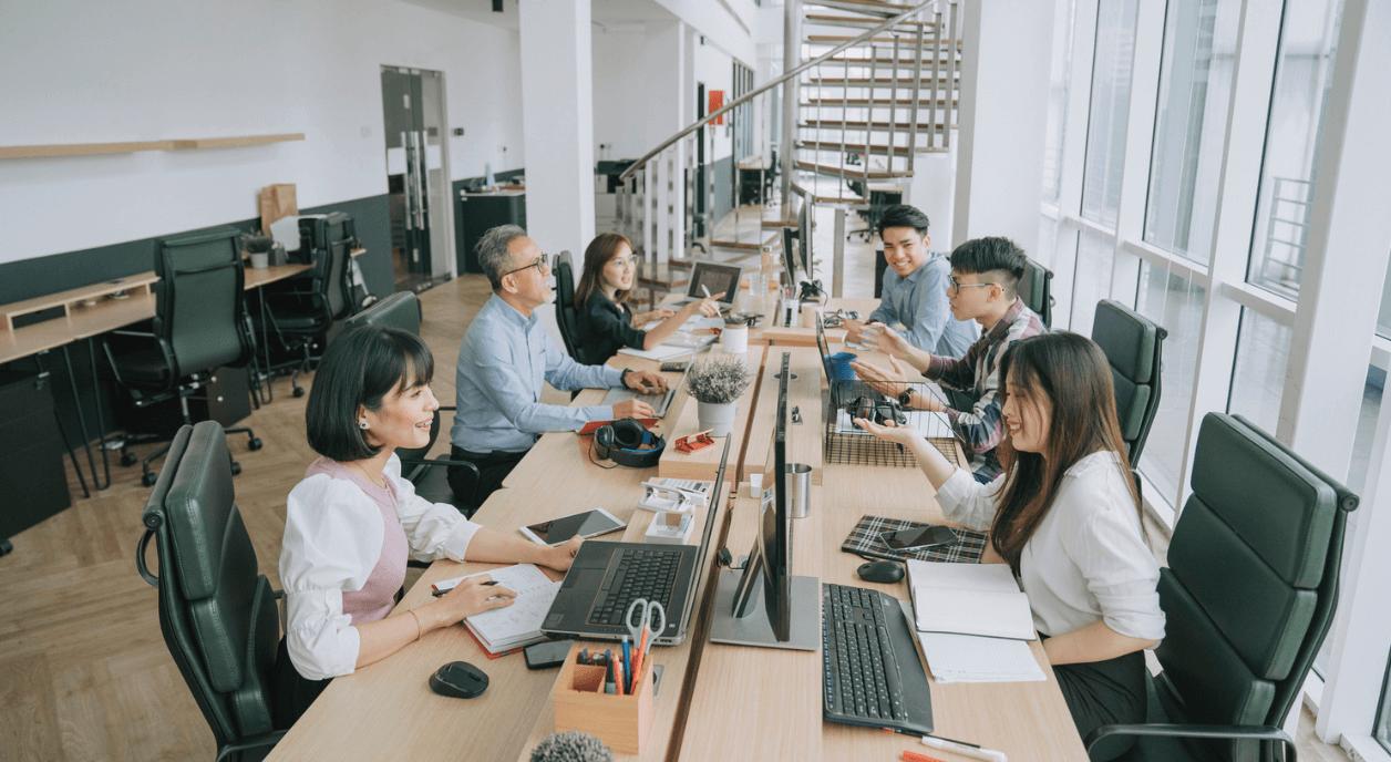 Colleagues interacting in an open office setting.