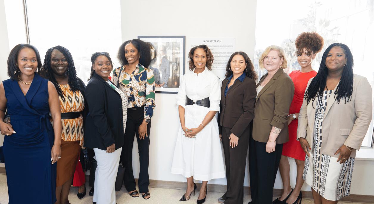 Author Kaci Patterson stands in the middle of a row of nine women leaders.